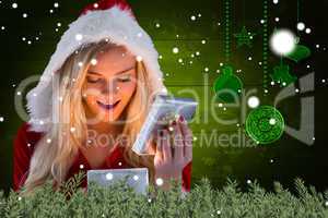 Composite image of sexy santa girl opening gift