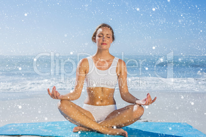 Fit woman sitting in lotus pose on the beach