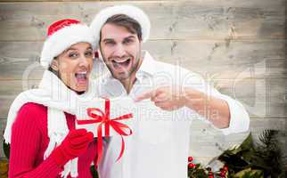 Composite image of festive young couple holding gift