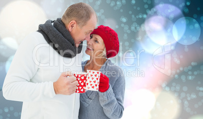 Composite image of mature couple holding mugs