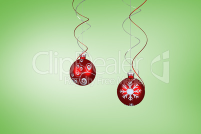 Composite image of two hanging red bauble decorations