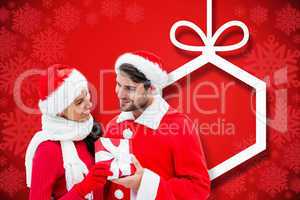 Composite image of festive young couple holding gift