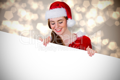 Composite image of pretty girl in santa costume showing card Composite image of pretty girl in santa costume showing card