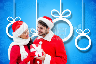 Composite image of festive young couple holding gift