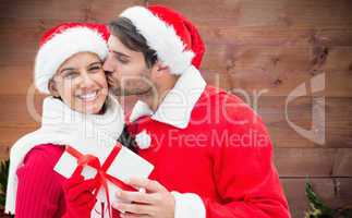 Composite image of festive young couple holding gift