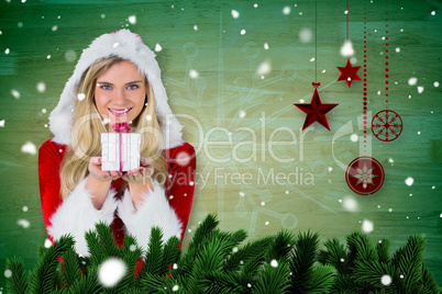 Composite image of pretty girl in santa outfit holding gift