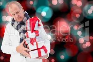 Composite image of festive man holding christmas gifts