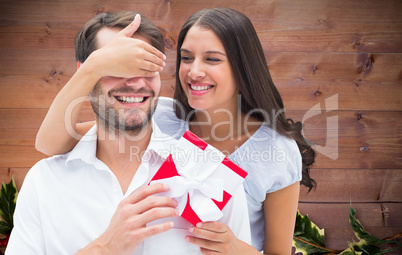 Composite image of woman surprising boyfriend with gift