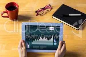 Composite image of businesswoman using tablet at desk