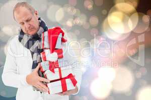 Composite image of festive man holding christmas gifts