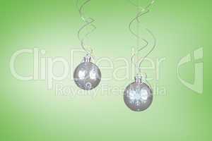 Composite image of two hanging silver bauble decorations