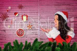 Composite image of pretty girl in santa outfit blowing