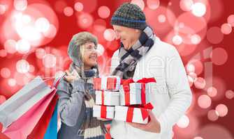 Composite image of festive mature couple holding christmas gifts