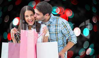 Composite image of happy couple with shopping bags