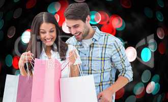 Composite image of happy couple with shopping bags