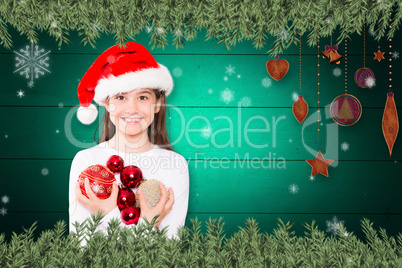Composite image of festive little girl smiling at camera holding