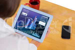 Composite image of businesswoman using tablet at desk