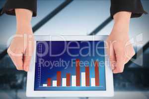 Composite image of businesswomans hands holding tablet