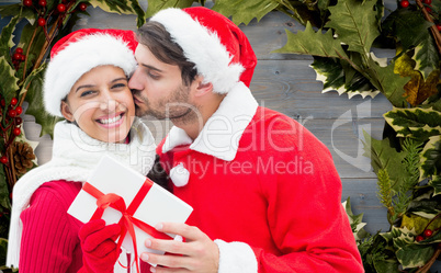 Composite image of festive young couple holding gift