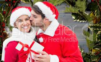 Composite image of festive young couple holding gift