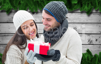 Composite image of winter couple holding gift Composite image of winter couple holding gift