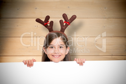Composite image of festive little girl showing card Composite image of festive little girl showing card
