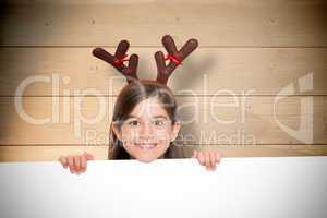 Composite image of festive little girl showing card