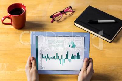 Composite image of businesswoman using tablet at desk