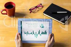 Composite image of businesswoman using tablet at desk