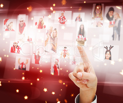 Composite image of hand pointing to christmas people collage