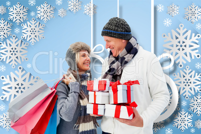 Composite image of festive mature couple holding christmas gifts