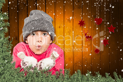 Composite image of wrapped up little girl blowing over hands