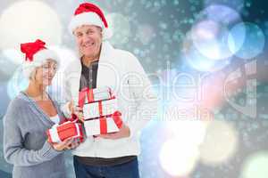 Composite image of festive mature couple holding christmas gifts