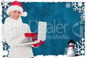 Composite image of festive woman holding laptop