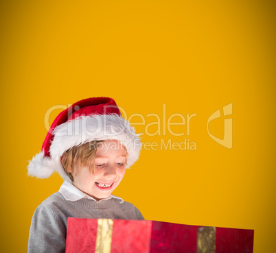 Composite image of festive boy opening gift