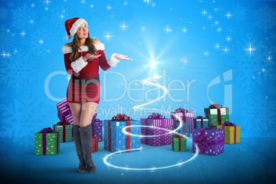 Composite image of pretty girl in santa costume holding hand out Composite image of pretty girl in santa costume holding hand out