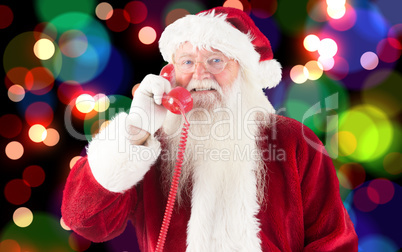 Composite image of santa claus on the phone