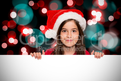 Composite image of festive little girl showing card