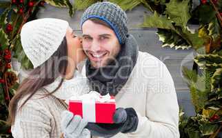 Composite image of winter couple holding gift