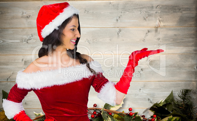 Composite image of pretty girl presenting in santa outfit