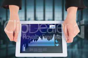 Composite image of businesswomans hands holding tablet