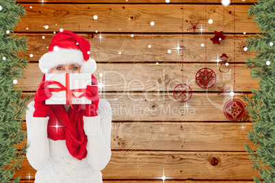 Composite image of festive woman holding gift