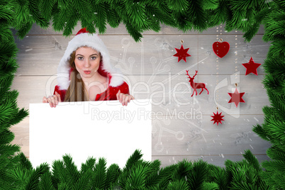 Composite image of pretty girl in santa costume showing card