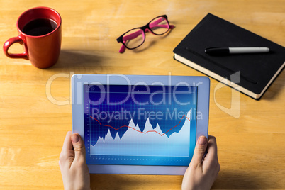 Composite image of businesswoman using tablet at desk