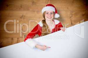 Composite image of pretty girl in santa costume showing card