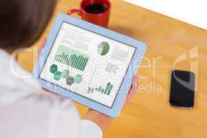 Composite image of businesswoman using tablet at desk