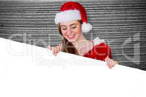 Composite image of pretty girl in santa costume showing card