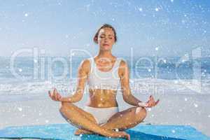 Fit woman sitting in lotus pose on the beach
