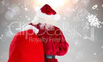 Composite image of santa claus carrying sack