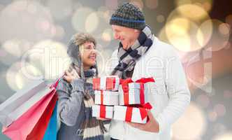 Composite image of festive mature couple holding christmas gifts